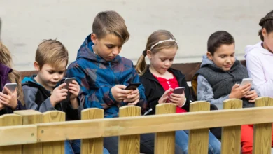 دعوى قضائية في نيويورك ضد شركات التواصل الاجتماعي 8 Outdoor portrait of girls and boys playing with phones 638179148 2714x1108