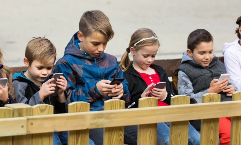 Outdoor portrait of girls and boys playing with phones 638179148 2714x1108