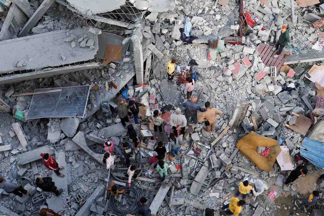 فلسطينيون يتفقدون موقع غارة إسرائيلية استهدفت منزلاً في خان يونس جنوب قطاع غزة. 